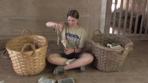 Ann Scherer using a drop-spindle to twist the wool into yarn.